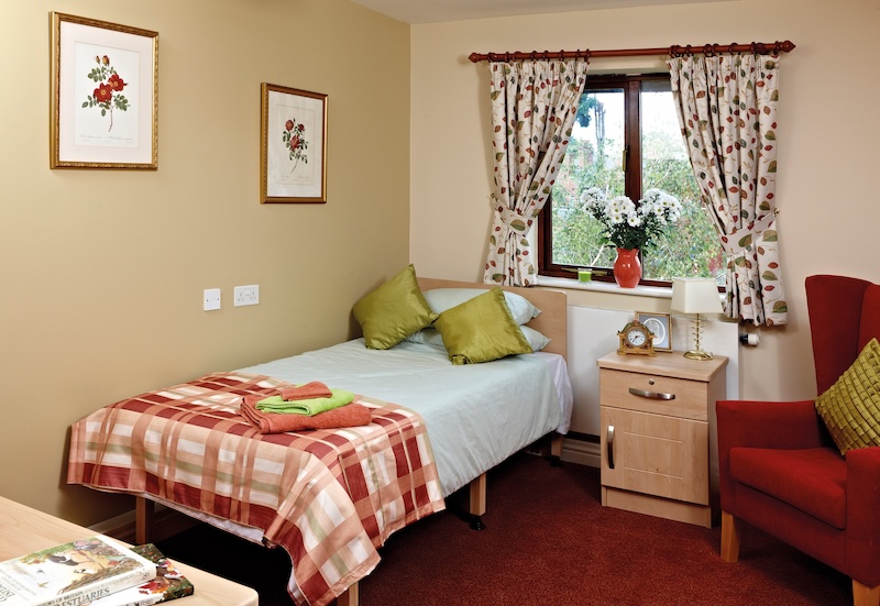 Bedroom with red carpet and green pillows