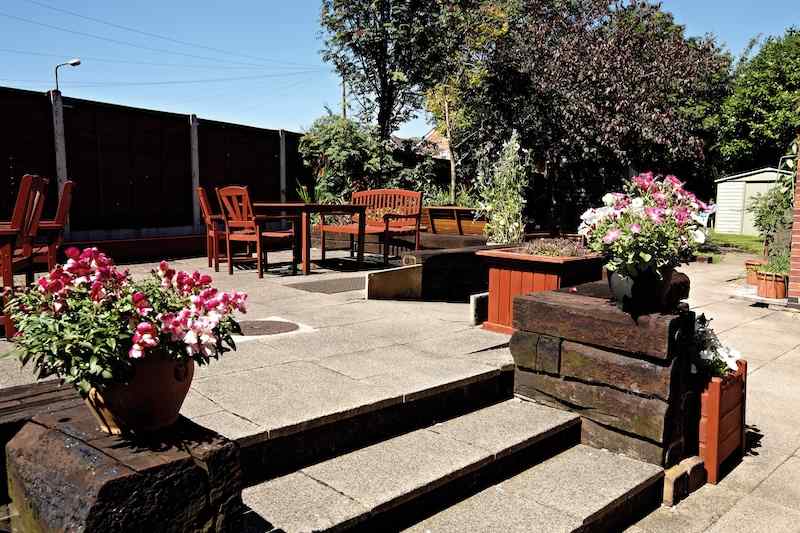 Waterside patio with wooden furniture